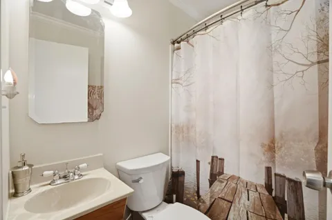 a bathroom with a sink mirror and a toilet