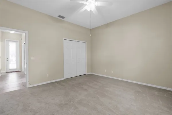 an empty room with a chandelier fan