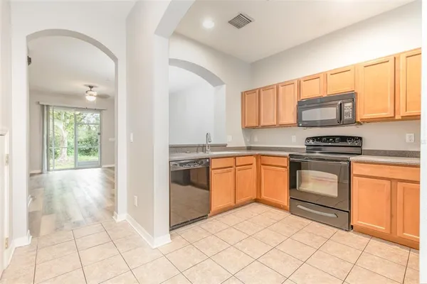 a kitchen with granite countertop a stove top oven sink and cabinets