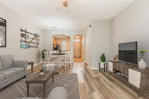 a living room with furniture a flat screen tv and a dining table