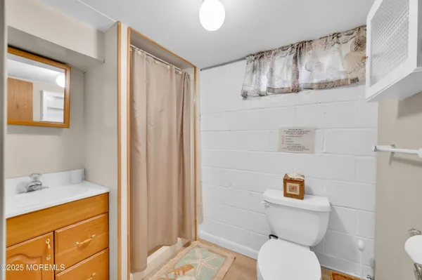 a bathroom with a sink a toilet and shower curtain