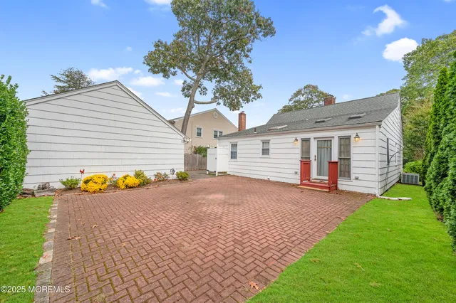 a view of a house with backyard and a tree