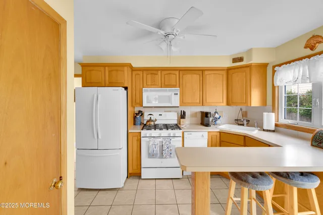 a kitchen with a refrigerator a stove top oven a sink and cabinets