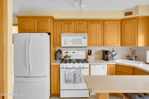 a kitchen with a refrigerator a stove a sink and cabinets