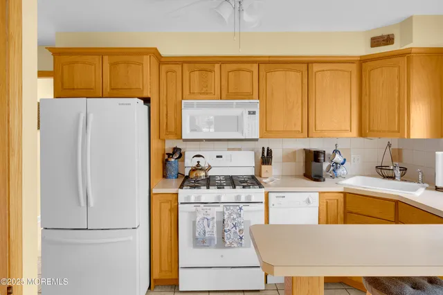 a kitchen with a refrigerator a stove a sink and cabinets