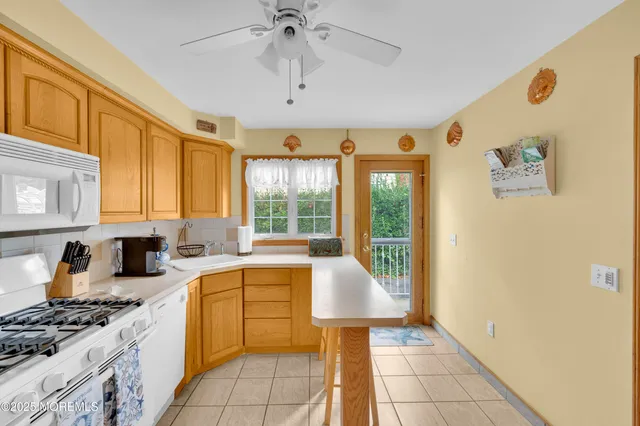 a kitchen with a sink a stove top oven and cabinetry