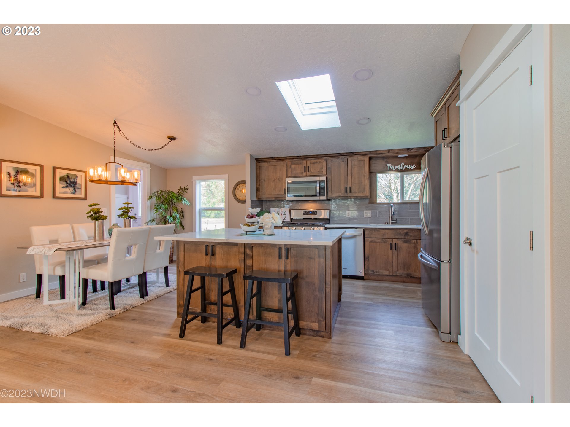 1625 River Loop 1 Eugene, OR 97404 - Photo 8 of 32 a open kitchen with stainless steel appliances kitchen island granite countertop a refrigerator a stove a sink dishwasher and white cabinets with wooden floor