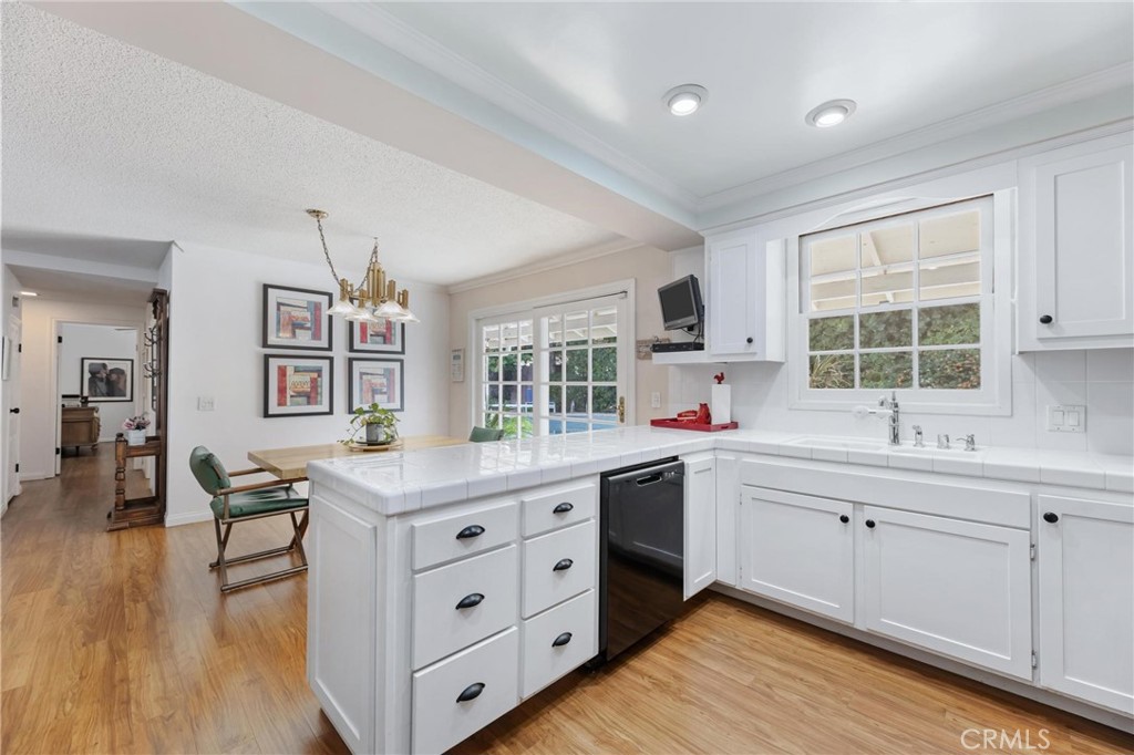 10800 Bismarck Avenue Porter Ranch, CA 91326 - Photo 12 of 29 a kitchen that has a lot of cabinets in it and wooden floors