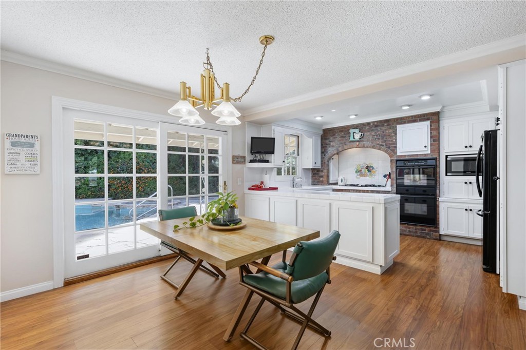 10800 Bismarck Avenue Porter Ranch, CA 91326 - Photo 7 of 29 a kitchen with kitchen island a dining table and wooden floor
