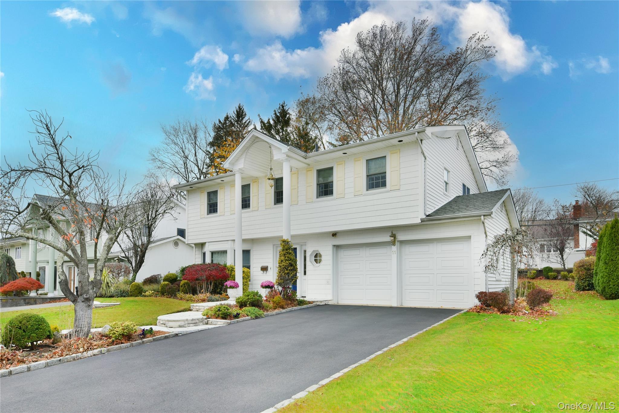 11 Joy Drive Manhasset Hills, NY 11040 - Photo 3 of 41 a view of a house with a yard and garage