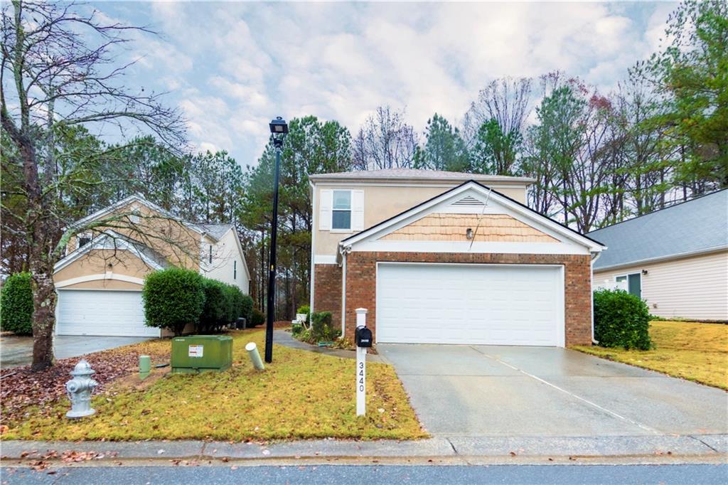 a view of a white house with a small yard and large tree