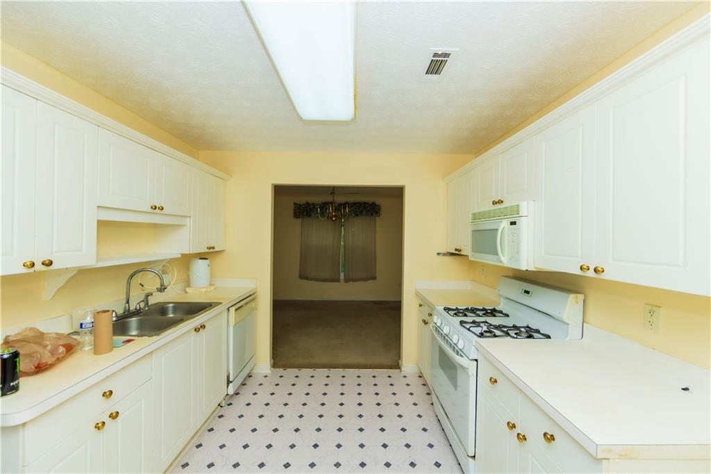 3440 Maple Valley Drive Cumming, GA 30040 - Photo 14 of 73 a kitchen with a sink a stove and cabinets