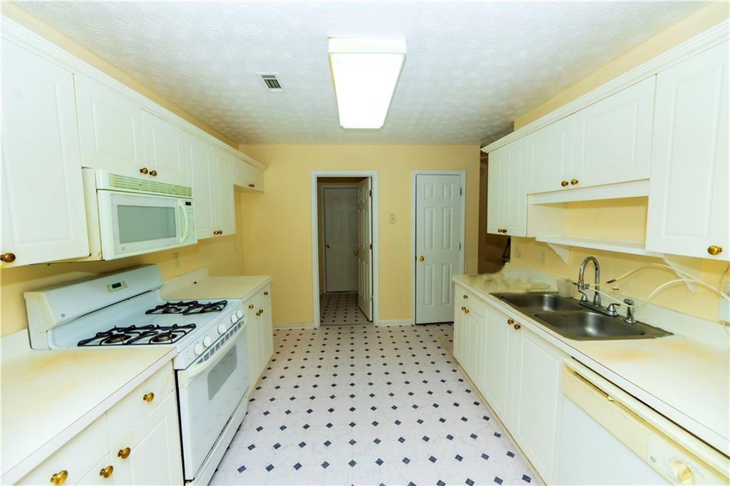 3440 Maple Valley Drive Cumming, GA 30040 - Photo 15 of 73 a kitchen with a sink a stove and cabinets