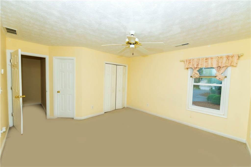 3440 Maple Valley Drive Cumming, GA 30040 - Photo 31 of 73 an empty room with chandelier fan and windows