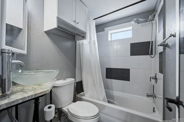 a bathroom with a granite countertop toilet sink and mirror