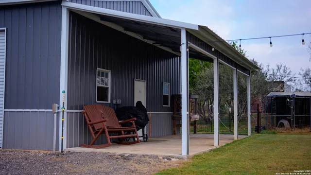 a backyard of a house with table and chairs