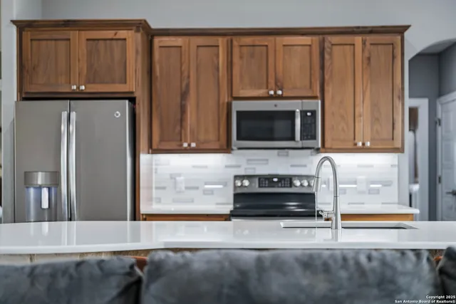a kitchen with granite countertop a refrigerator stove and microwave