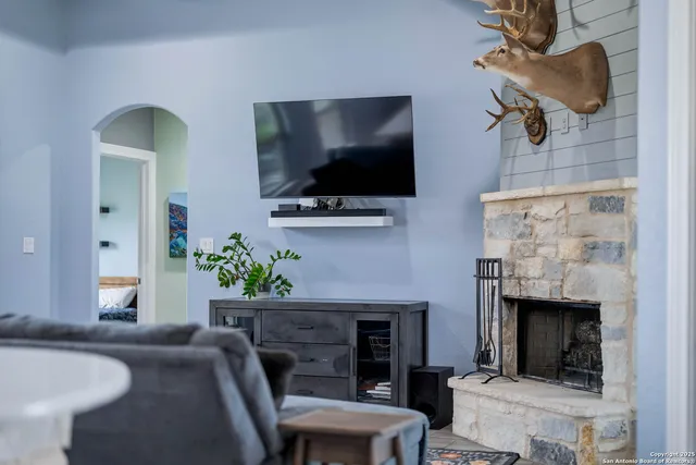 a living room with furniture a flat screen tv and a fireplace