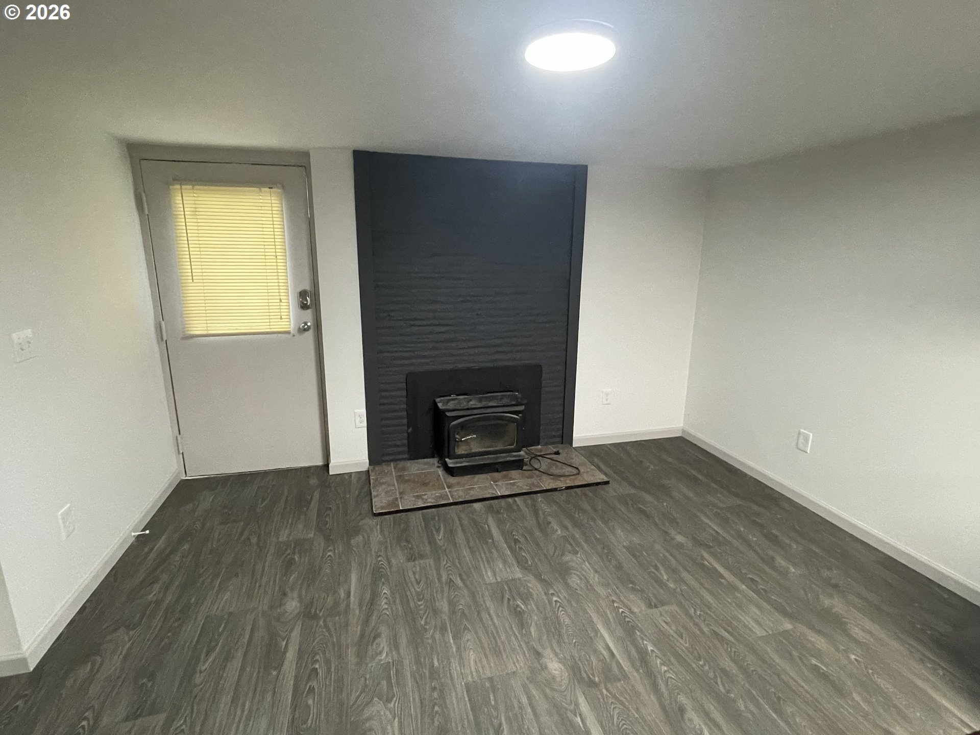 144 Southeast 85th Avenue Portland, OR 97216 - Photo 5 of 43 a view of an empty room with wooden floor and a window