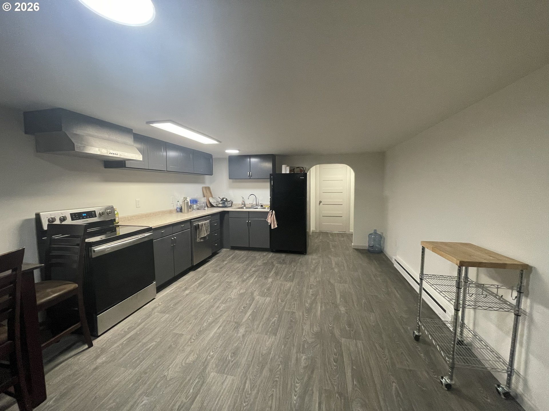144 Southeast 85th Avenue Portland, OR 97216 - Photo 8 of 43 a large kitchen with a wooden floor and stainless steel appliances