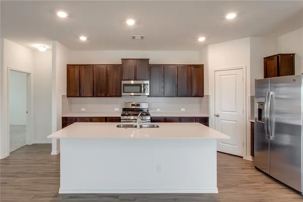 a kitchen with stainless steel appliances a sink stove and refrigerator