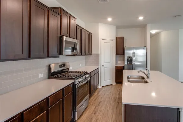 a kitchen with wooden cabinets a sink and a stove