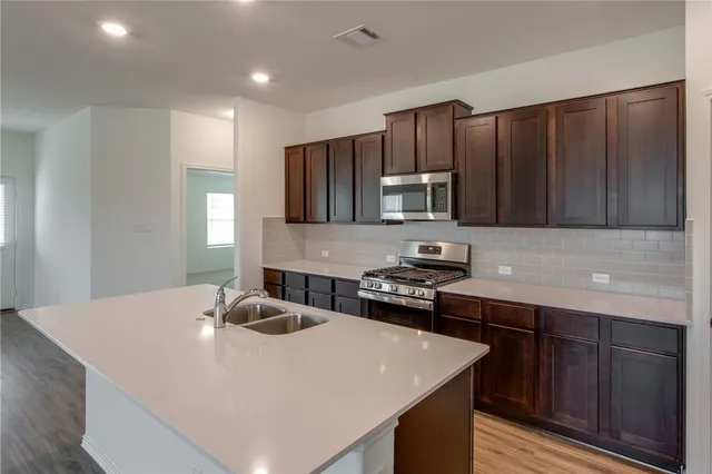 a kitchen with wooden cabinets a sink and a stove