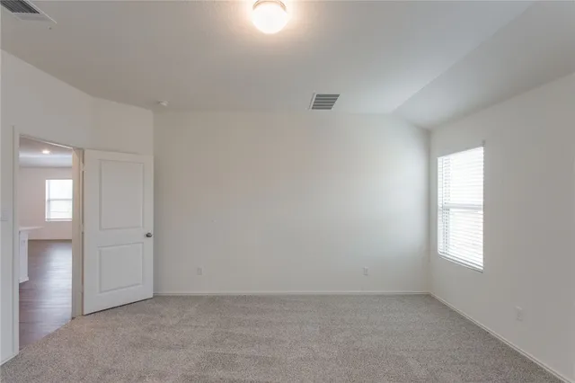 an empty room with windows and closet