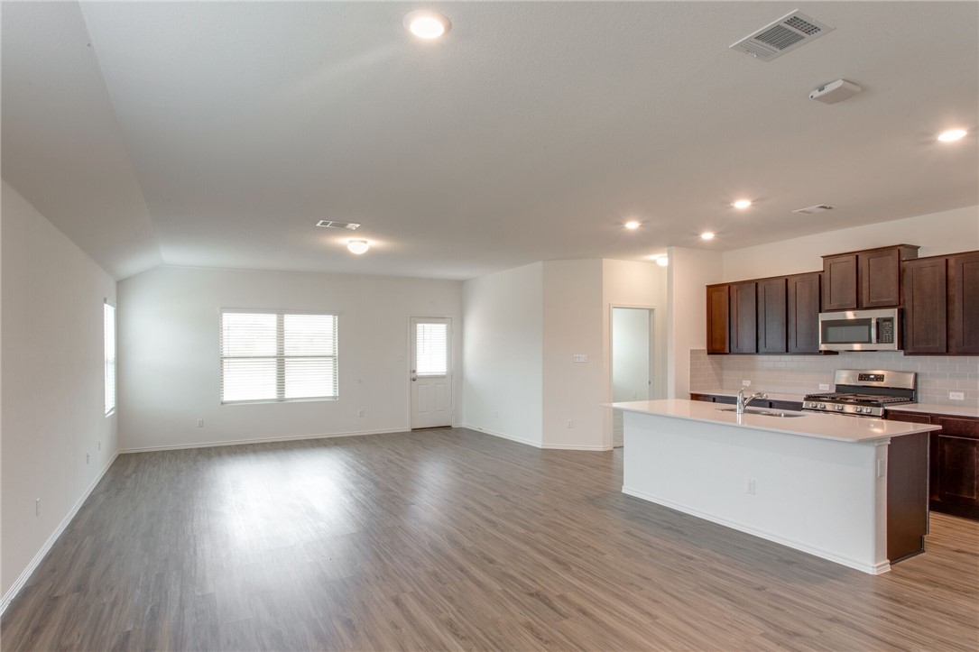 3417 Pauling Loop Round Rock, TX 78665 - Photo 7 of 31 a kitchen with stainless steel appliances granite countertop a sink stove and wooden floor