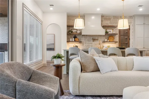 a kitchen with a dining table chairs sink and white cabinets