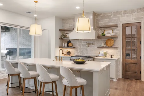 a kitchen with stainless steel appliances granite countertop a stove a refrigerator and a cabinets