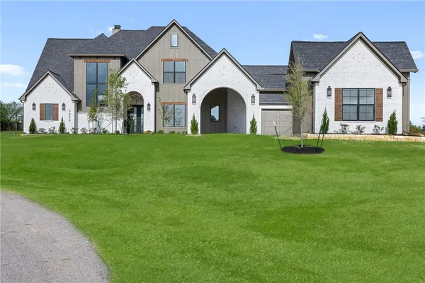 a view of white house with a yard and garage