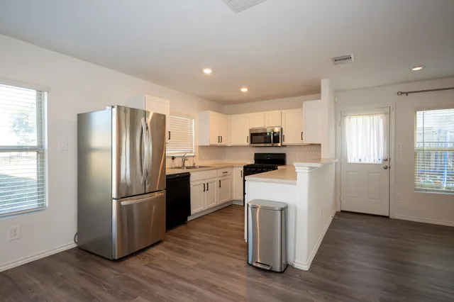 a kitchen with white cabinets and stainless steel appliances