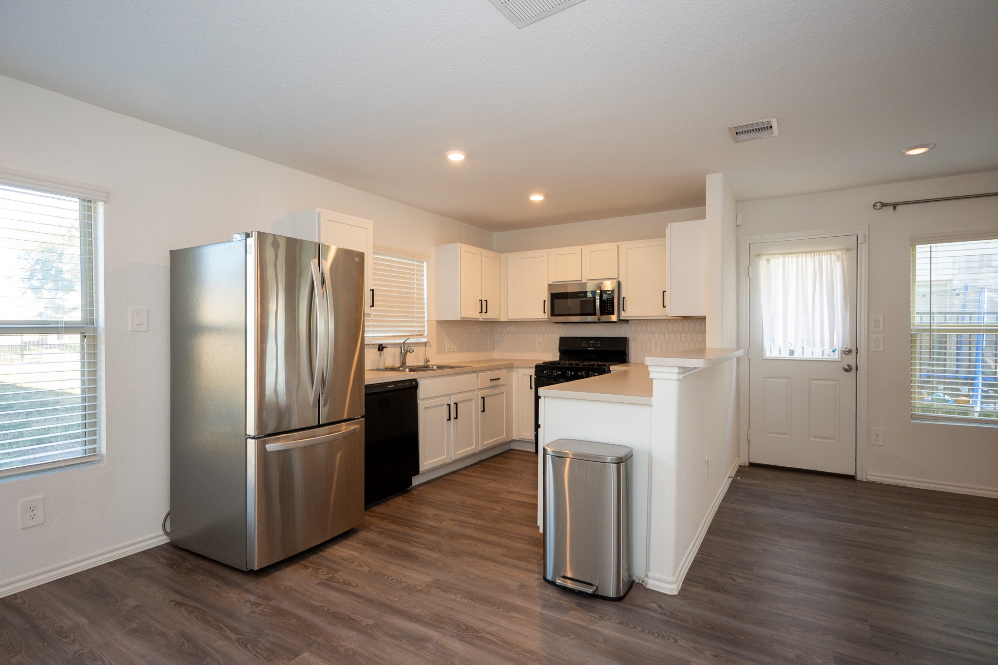 5403 Rosser Ruby Way Brookshire, TX 77423 - Photo 11 of 39 a kitchen with white cabinets and stainless steel appliances