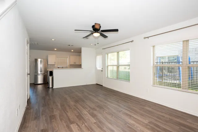 a view of a big room with wooden floor and windows
