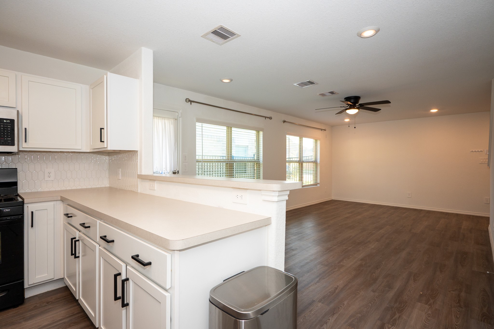 5403 Rosser Ruby Way Brookshire, TX 77423 - Photo 9 of 39 a kitchen with a stove and white cabinets
