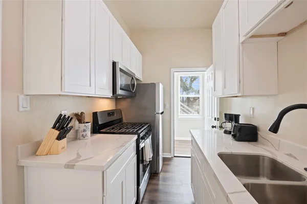 a kitchen that has a sink and a stove top oven