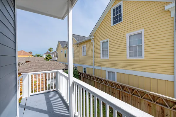 a view of a balcony with wooden floor and fence