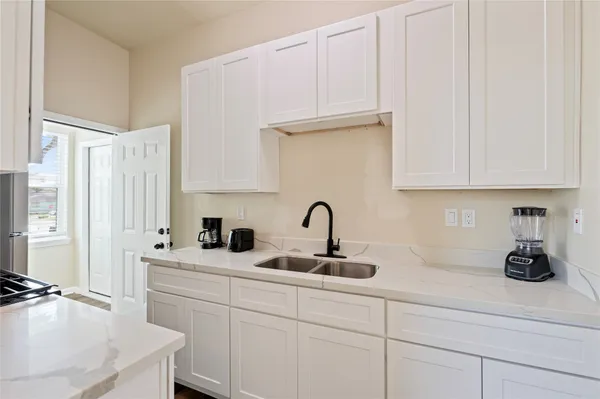 a kitchen with white cabinets and a sink