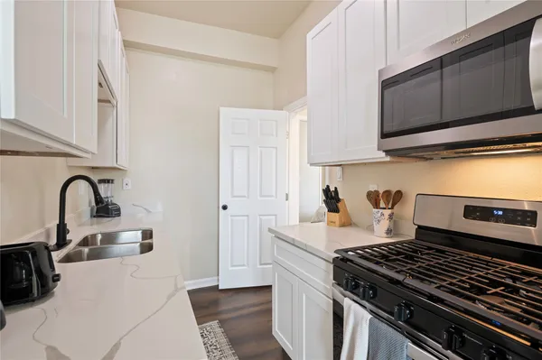 a kitchen with granite countertop a stove and a sink