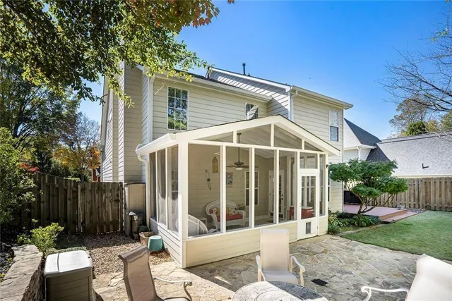 a view of a chair and table in backyard of the house