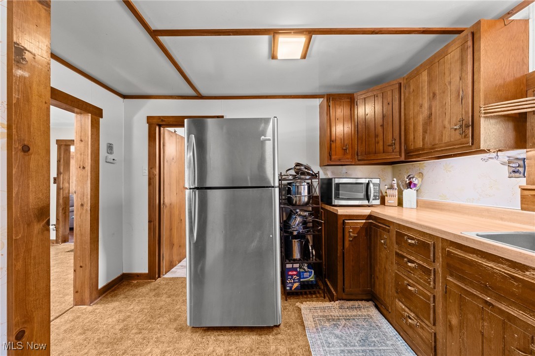 152 Harper Road Streetsboro, OH 44241 - Photo 14 of 34 Kitchen featuring appliances with stainless steel finishes, light countertops, light carpet, and brown cabinets