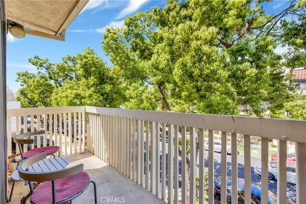 a balcony with chairs and a potted plant