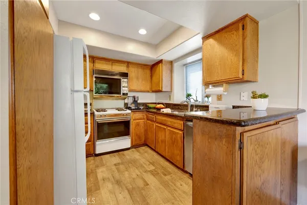 a kitchen with granite countertop a stove a sink and a microwave