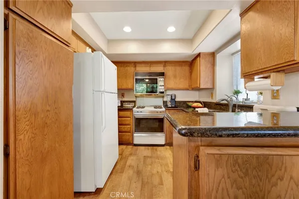 a kitchen with stainless steel appliances granite countertop a stove a sink and a refrigerator