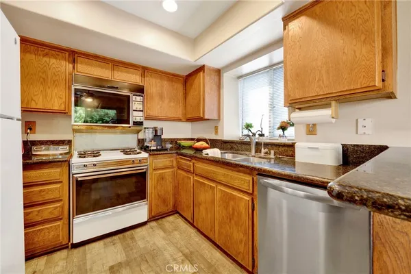 a kitchen with stainless steel appliances granite countertop a stove a sink and a microwave