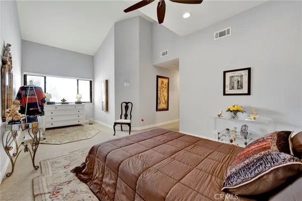 a bedroom with a large bed and a chandelier