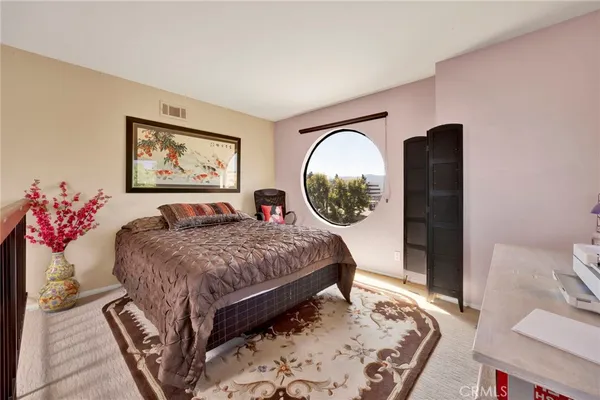 a bed room with a bed and a painting on the wall