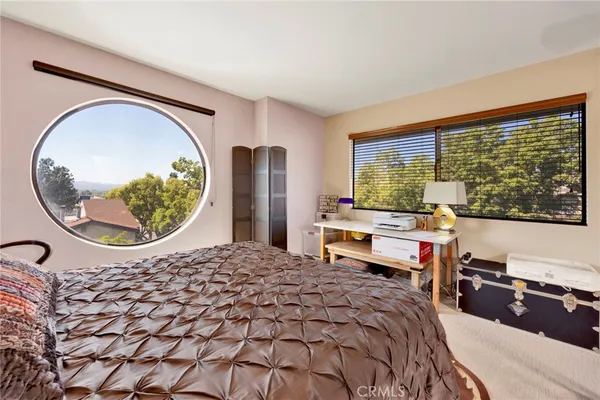 a bedroom with a bed and a large window with outer view