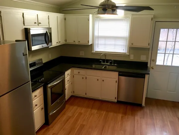a kitchen with granite countertop a stove a sink and a microwave